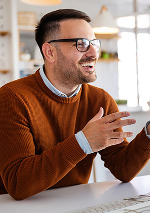 Man sitting at computer smiling.